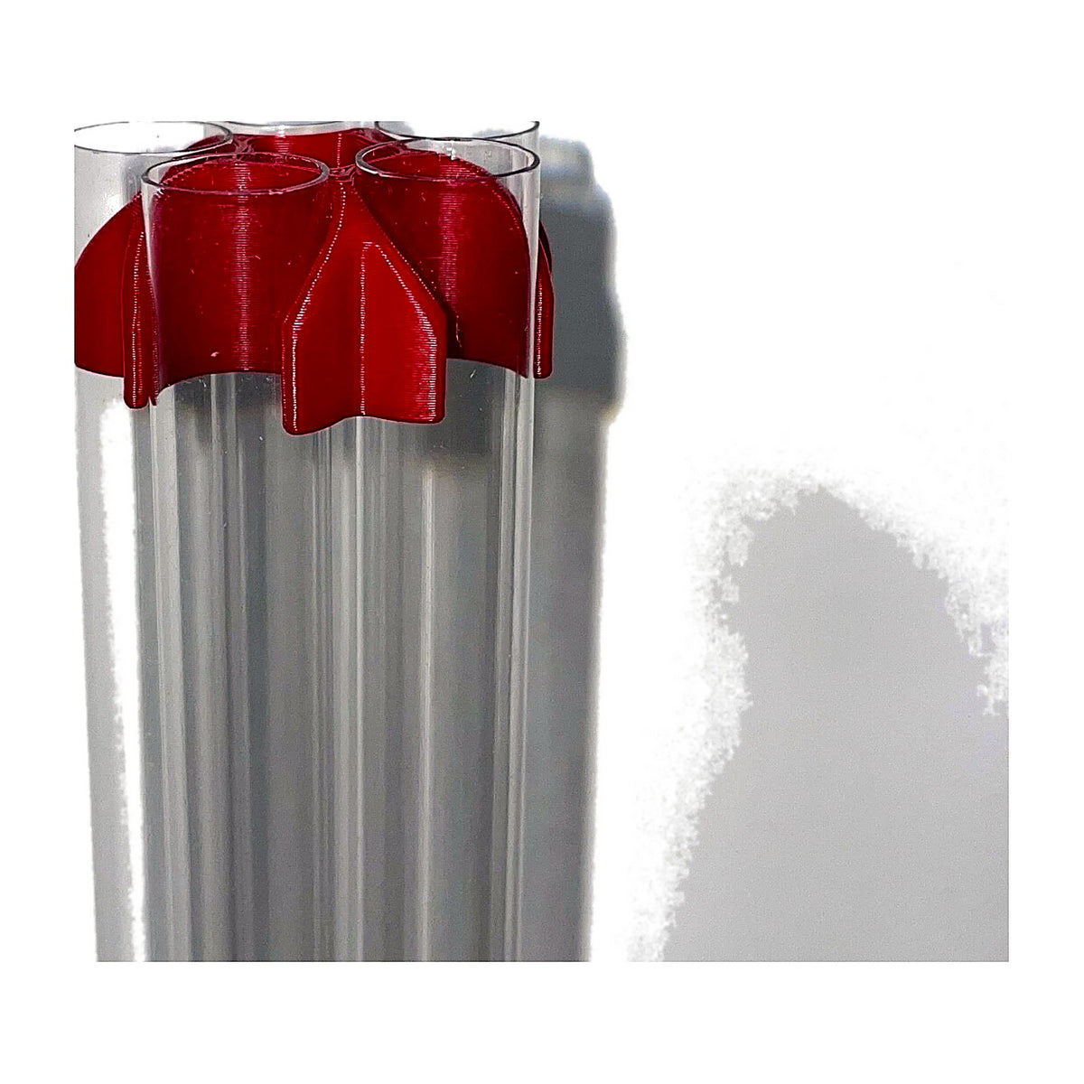 Red support clamp around the top of 5 clear case feed tubes