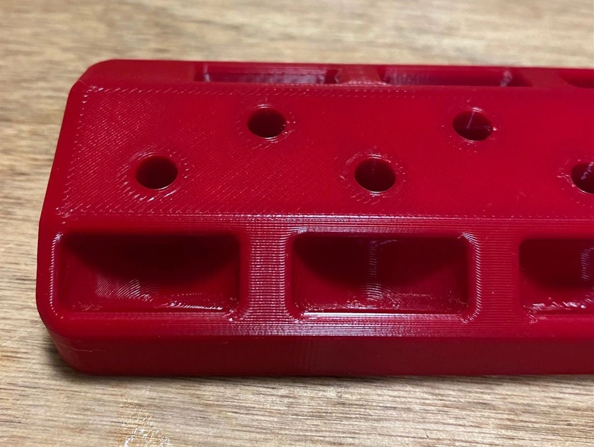 Close-up of the red rack showing gauge holes and shell holder slots