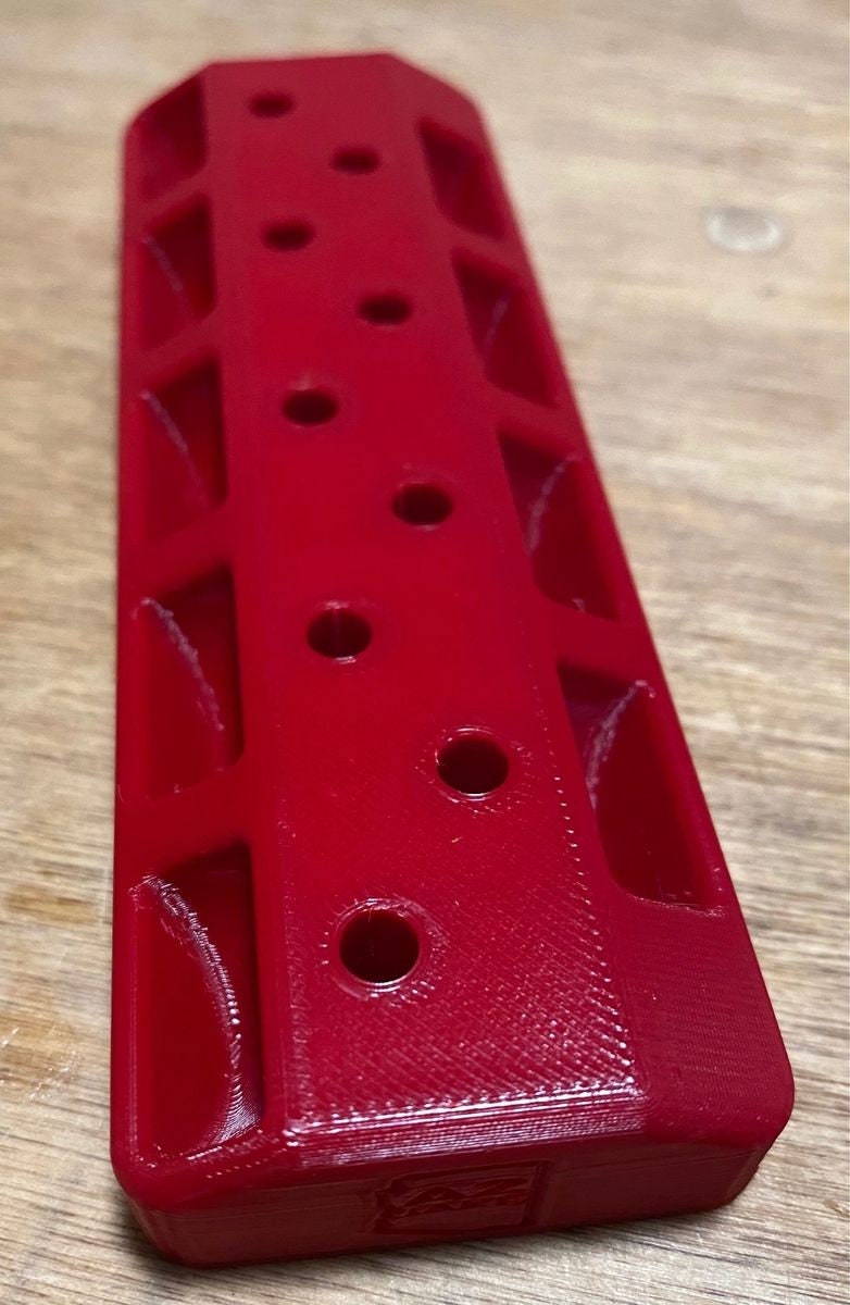 Red case length gauge rack, top view showing 9 gauge holes